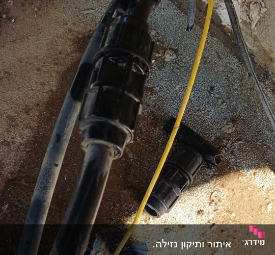 צינורות וחיבורים על קיר חיצוני עם אדמה